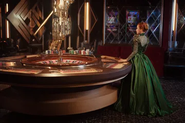 A man celebrating a winning moment on his laptop while gaming symbols float around him, capturing the excitement of ZBZBET games.